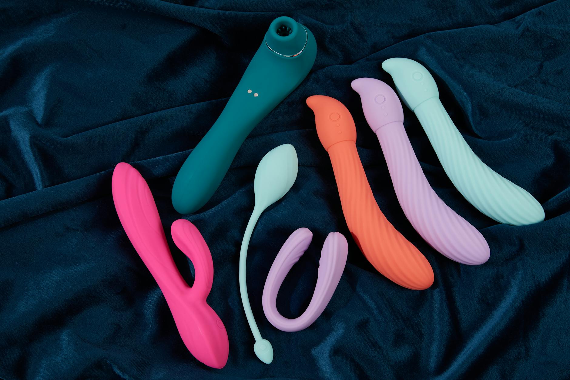 Close-up of a hand holding a vibrator against a minimalist purple backdrop