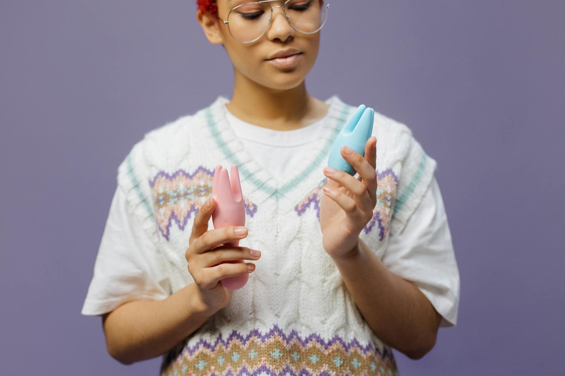 Woman holding a blue silicone vibrator contemplatively, representing sensory-aware pleasure exploration